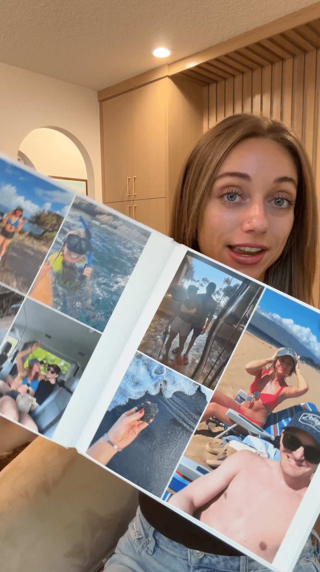 Ashley holding their finished photobook, smiling with delight
